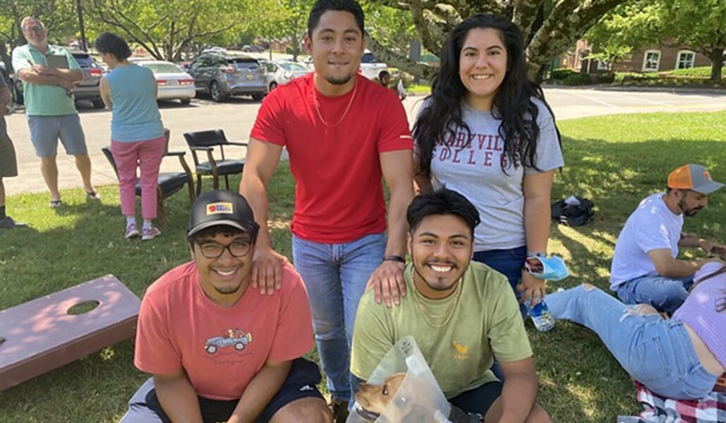 A Group Of People Sitting At A Park